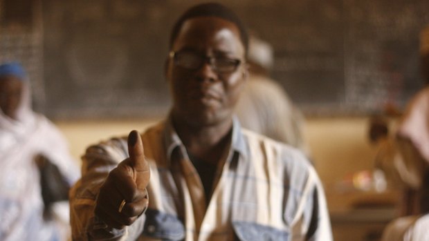 A man shows his thumb covered with ink as proof that he already voted, during elections in Niamey on Sunday. 