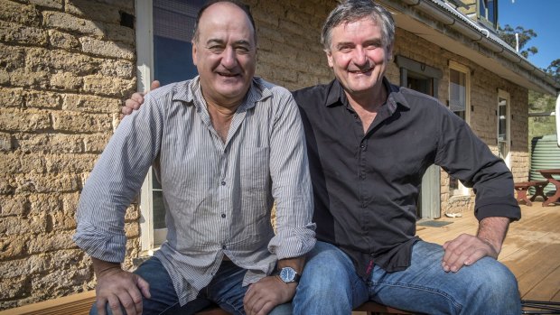 Philip Clark and Richard Glover on the verandah of the mud-brick house they started building when they were 25.