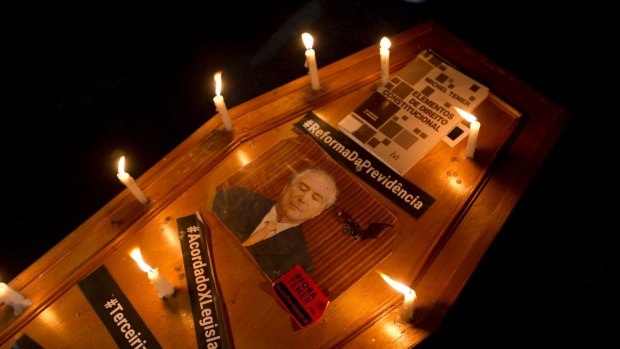 A mock coffin with a photo of Brazilian President Michel Temer is lit by candles during a protest in Rio de Janeiro, Brazil.