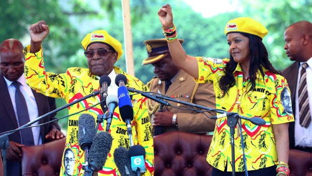 Zimbabwean President Robert Mugabe, left, and his wife Grace Mugabe chant the party's slogan during a solidarity rally in Harare last week.