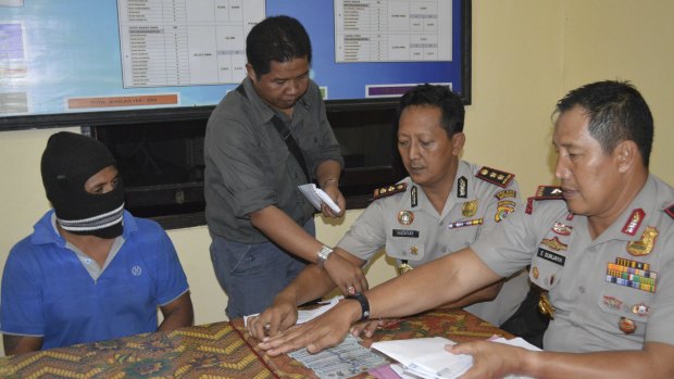 From left, seated: Captain Yohanis Humiang with head of the people smuggling division of Nusa Tenggara Timur, Ibrahim, and Rote police chief Hidayat.
