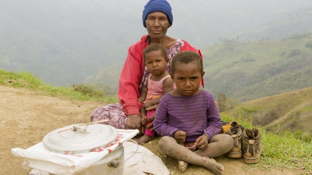 Gima Hebe and her two grandchildren trying to sell fried flour balls on the ridge above Odinoma village on Gun-Beroma Road. 