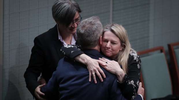 Opposition Leader Bill Shorten embraces Leader of the Opposition in the Senate Penny Wong and Senator Louise Pratt after speaking on Monday.