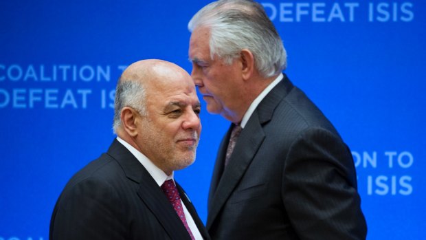 US Secretary of State Rex Tillerson, right, passes behind Iraqi Prime Minister Haider al-Abadi as he prepares to address the Meeting of the Ministers of the Global Coalition on the Defeat of ISIS, last week.