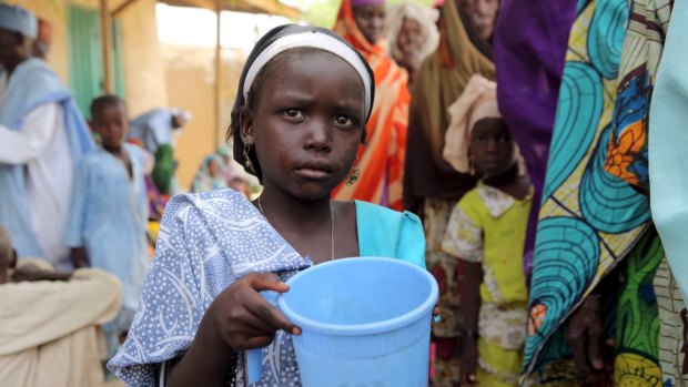 A girl drinks water as women queue for blankets and food in Damasak, Nigeria, last week. Boko Haram militants have kidnapped more than 400 women and children from Damasak.