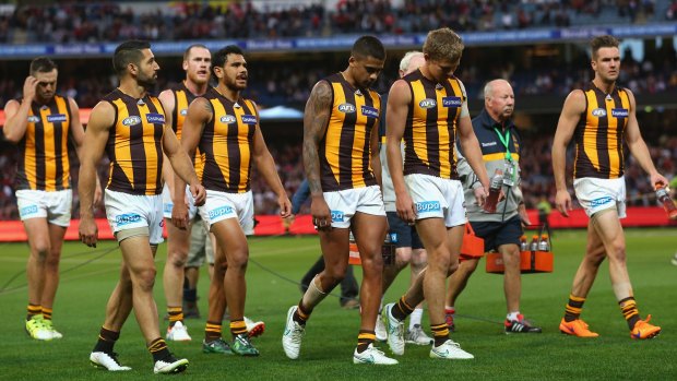 Dejected Hawthorn players leave the field after losing to Essendon.