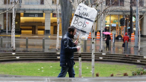 A person walks outside the federal courthouse in Seattle carrying a sign that reads "I'm with Bob and Immigrants," in reference to Washington state Attorney General Bob Ferguson.