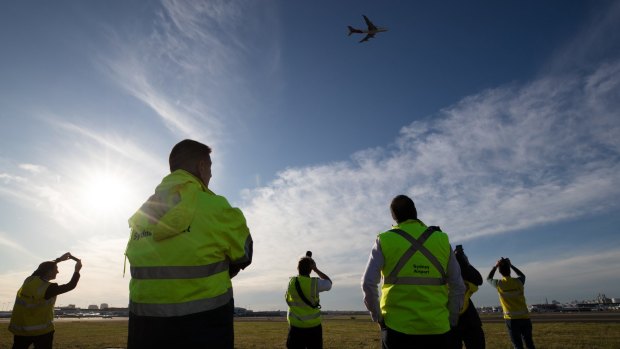 Qantas staff watch as the last Qantas 747 departs Sydney.