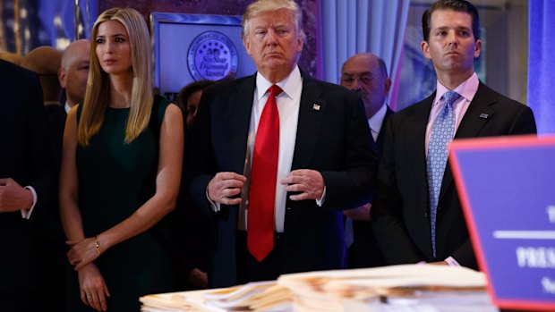 President-elect Donald Trump, accompanied by family members, waits to be introduced for the news conference.