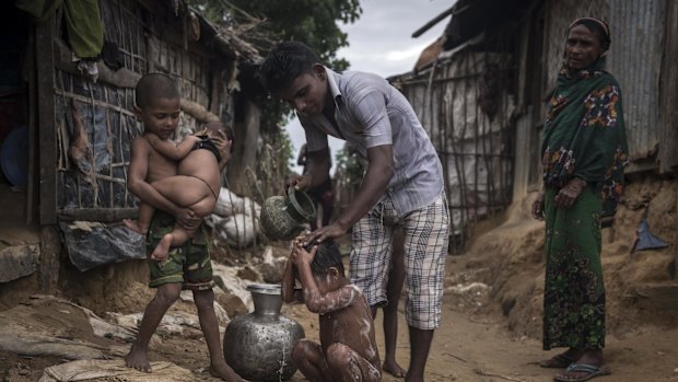 A Rogingya man bathes his child at the Kutupalong Refugee Camp in Teknaaf, Bangladesh, in June.