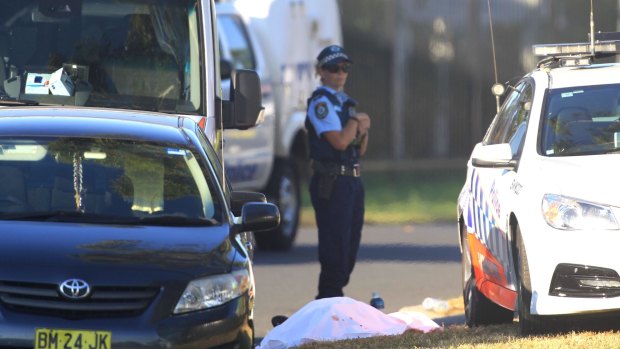 A police officer at the scene of the Ingleburn shooting on March 7, guarding what appears to be a body.