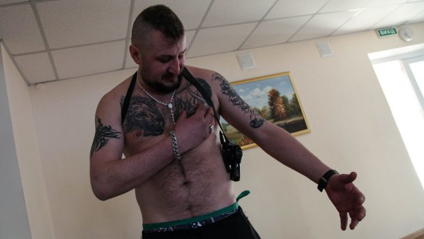 Narrow escape: Ukrainian soldier Ilya Andrushko shows off his tattoos - a lion and a Ukrainian emblem.