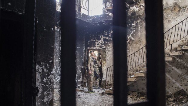A SWAT soldier in the building where they found an Islamic State prison in Fallujah. The downstairs rooms were used as group cells, and the upstairs for solitary confinement. 