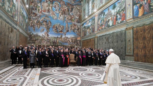 Pope Francis arrives to pose for a family photo with diplomats inside the Sistine Chapel. Tourists aren't allowed to take photos in here.