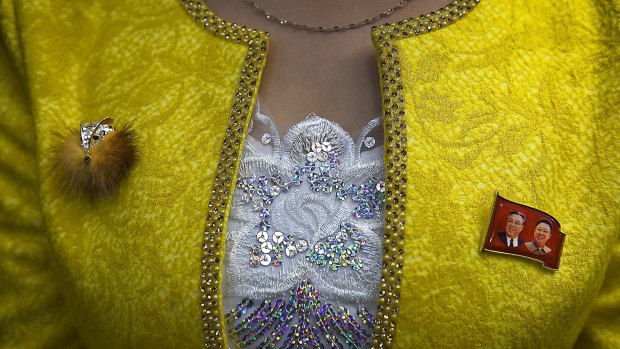 An elevator operator sports a bright jacket with embellishments of rhinestones, sequins and lace -- complete with a fox pin to offset a patriotic one.