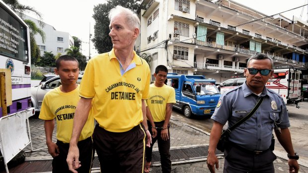 Peter Scully, foreground, arrives at the Cagayan De Oro court handcuffed to another inmate on the first day of his trial in September. 
