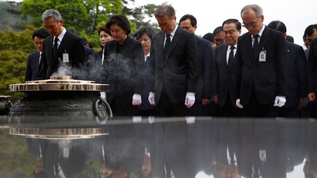 South Korea's new President Moon Jae-In, centre, pays silent tribute at the National Cemetery in Seoul on Wednesday.