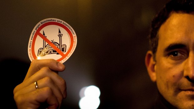 A demonstrator holds a sticker with a crossed mosque symbol during a march against "Islamification" in Berlin.