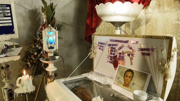 The body of Ramil Miranda lies in his coffin at his wake in Manila, Philippines. The known drug user was beaten and stabbed near his home in April.