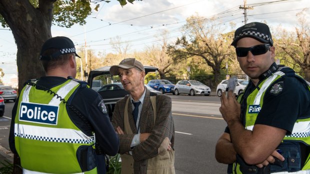 Police question a man outside the East Melbourne fertility clinic on Monday. 