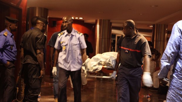 Mali security personnel remove a body from the Radisson Blu hotel.