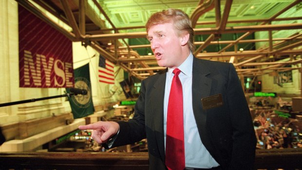 Donald Trump posing for photos above the floor of the New York Stock Exchange in 1995.
