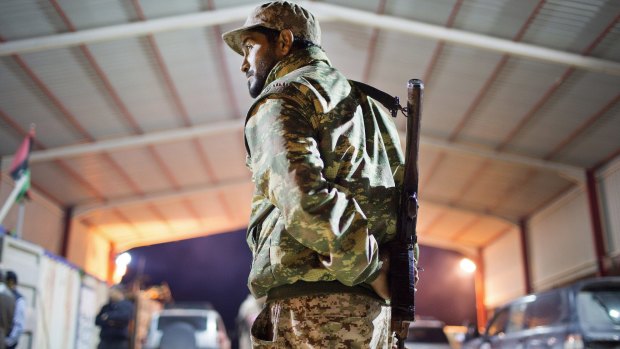 A Libyan military soldier stands guard at the entrance of a town 110 kilometers from Sirte.