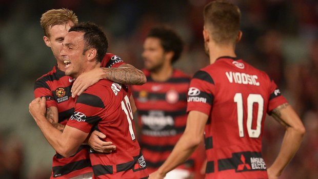 Mark Bridge of the Wanderers celebrates with his teammates after scoring against Newcastle.