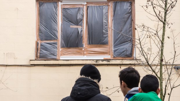 The broken windows of a house in which terror suspects were hiding are covered with plastic the day after the raid.