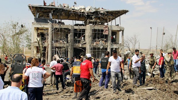 Turkish authorities stand outside a damaged police station after an explosion near Diyarbakir in August. Kurdish rebels detonated a car bomb at the police station killing two police officers and a young child, officials said.  