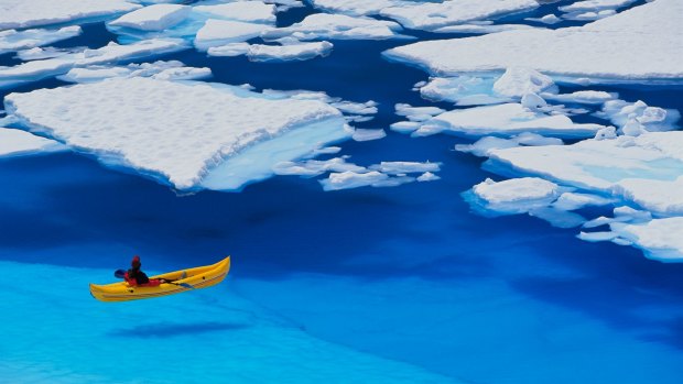 A kayaker navigates through a melt pond in the Juneau Icefield, Coast Mountains, Tongass National Forest.