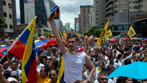 Opposition supporters hold Venezuelan flags and sing the national anthem during the protest in Caracas on Thursday.