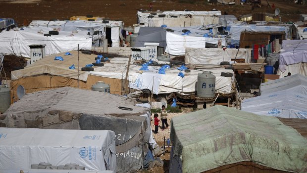 Syrian refugees outside their tents at a  camp in Hosh Hareem, Bekaa Valley, east Lebanon.