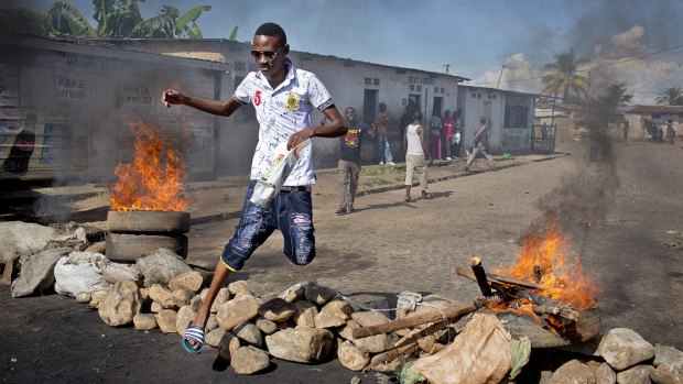 A civilian jumps over a burning barricade of rocks erected by residents to protect themselves from police in Bujumbura on Thursday.
