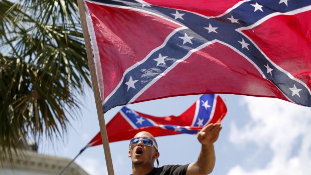 A member of the Ku Klux Klan yells as he flies a Confederate flag during the rally in South Carolina on July 18.