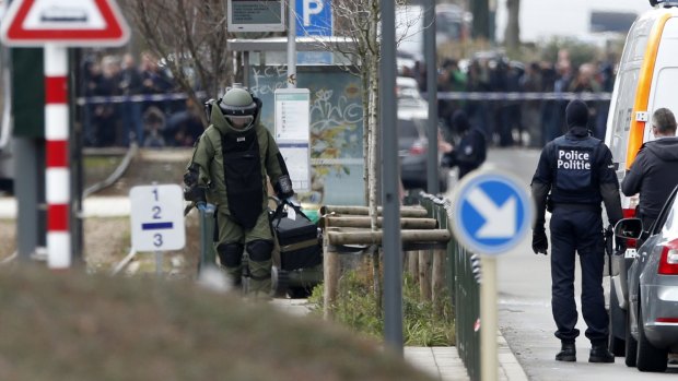 A member of emergency services wearing protective clothing investigates the area around a tram station in Schaerbeek, Belgium, on Friday.