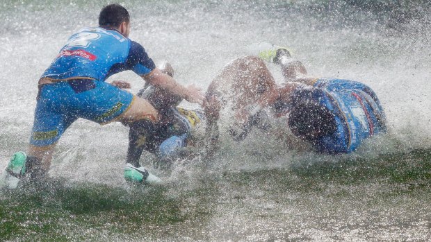 'Swimming lessons': The waterlogged pitch reduced the Gold Coast-Cronulla match to a farce.