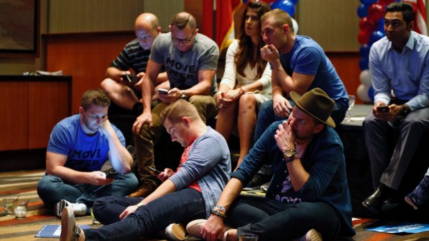 Hillary Clinton supporters in Dallas check results as Donald Trump began to pick up wins in key states.