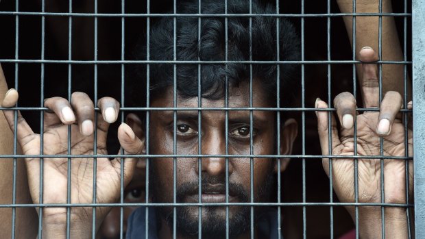 Bangladeshi migrant Jahangir Hussain looks out of a police van  in Langkawi on Monday.