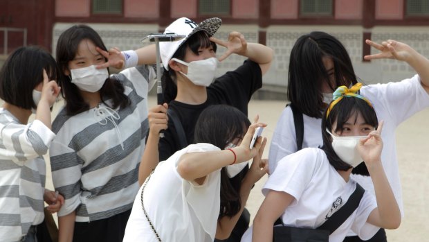 Tourists wear masks as a precaution against the MERS virus at the Gyeongbok palace on Jon Thursday.