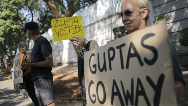 Protesters stand outside the Gupta family's Johannesburg residence to protest against the family's ties to South African President Jacob Zuma - an arrangement known as "Zupta" - in April.