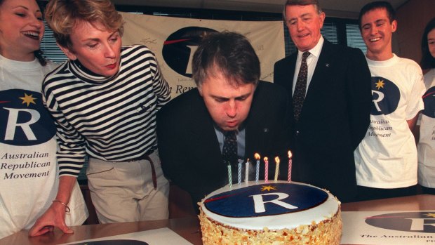 Malcolm Turnbull blows out the candles on a cake marking seven years of the ARM, flanked by Wendy Machin and Neville Wran.