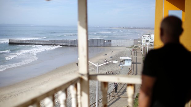 US Marine veteran Antonio Romo, who was deported, looks out from his apartment balcony in Tijuana, Mexico, where he can see the US border wall separating San Diego from Tijuana.
