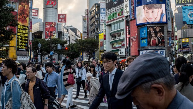 Pedestrians cross the road at Japan's famous Shibuya crossing.