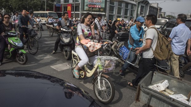 On the congested roads of China's capital, a conflict is playing out between increasing numbers of both car drivers and couriers who depend on powered two- and three-wheelers.