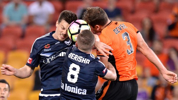  Luke DeVere of the Roar competes for the ball against Besart Berisha and James Donache of the Victory.