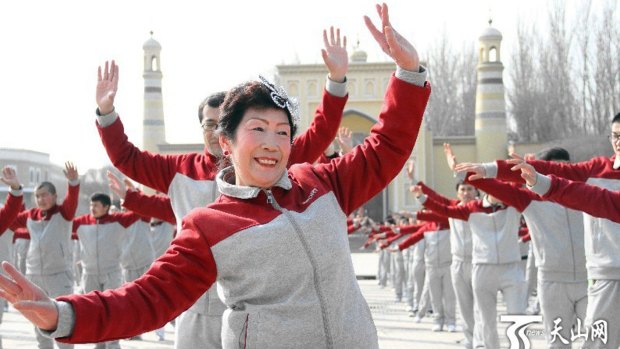 A campaign in Xinjiang is determinedly cheery where hundreds of people in matching outfits, both Uighur and Han, lined up in a coordinated square dance.