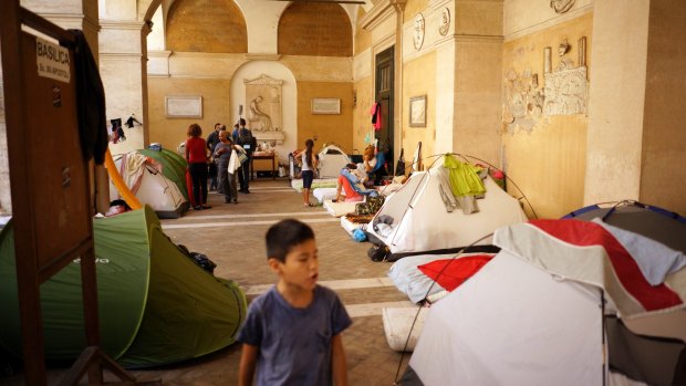People camp under the portico of the Roman Catholic Basilica of the "Twelve Holy Apostles" in downtown Rome where 100 people, including homeless Italians and migrants are sheltering.