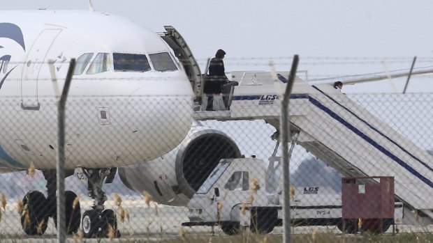 A passenger leaves a hijacked EgyptAir aircraft after landing at Larnaca Airport in Cyprus. 