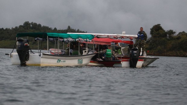 Soldiers and rescue workers at the site where a ferry sank in a reservoir in Guatape, Colombia.